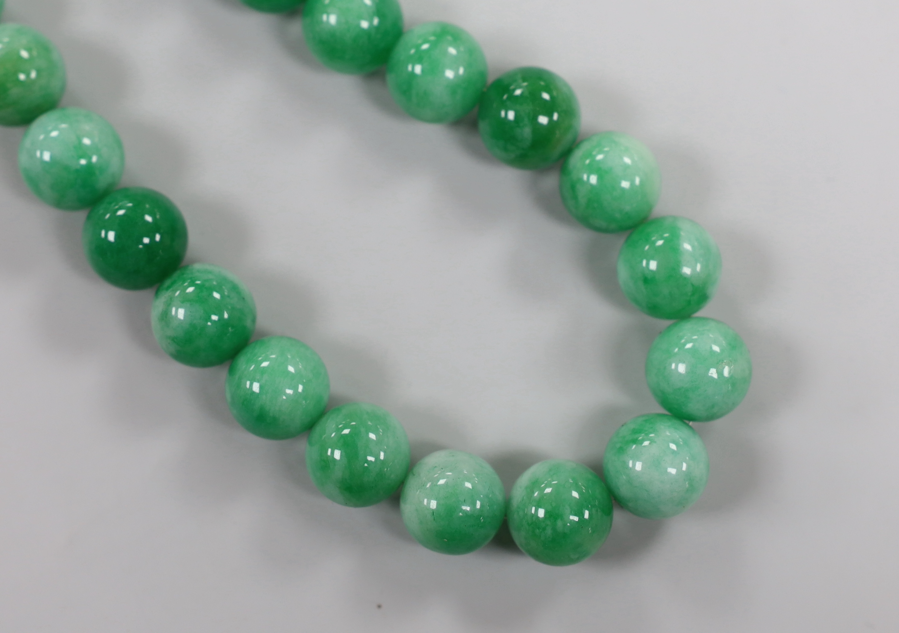 A single strand jade bead necklace, with white metal clasp, beads approximately 14mm in diameter, 44cm.